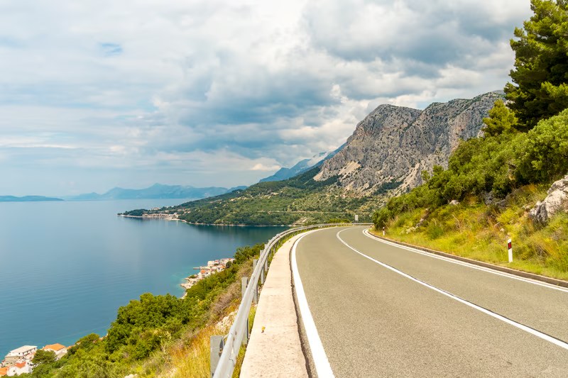 Coastal road curving beside the sea and mountains