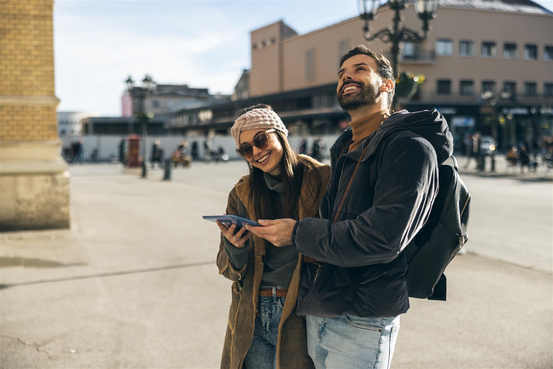 Travelers exploring a city with a digital tablet
